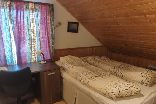 VigraAirbnb and Booking at Postvegen 95的一间卧室配有一张床、一张书桌和窗帘