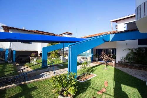 阿拉卡茹Pousada Villa Grécia的享有带蓝色屋顶的房屋后院的景色