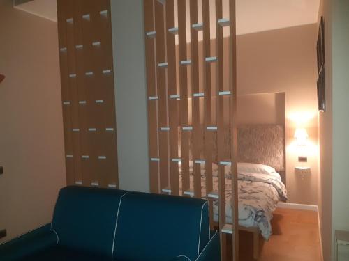 米兰Catenica的一间卧室配有一张床和一张蓝色椅子
