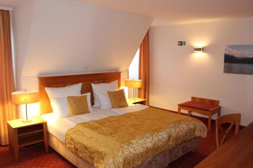 慕尼黑myMINGA4 - Hotel & serviced Apartments的酒店客房设有一张大床和两盏灯。