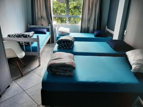 巴拉奈里奥-坎布里乌SAXÔNiA HOTEL的客房设有4张蓝色的床和窗户。
