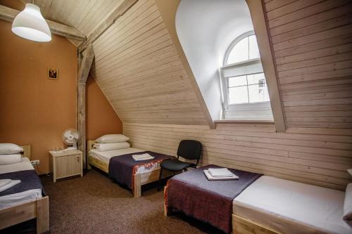 利沃夫Guest House "Arkhistratyg"的阁楼间 - 带两张床和窗户