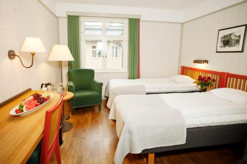 斯德哥尔摩辛肯丹姆STF酒店的酒店客房设有两张床和一张桌子。