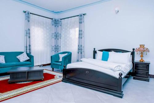 NamugongoOxymos Homes的一间卧室配有一张床和两张蓝色椅子