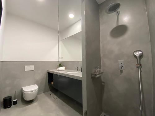波尔图Mus Boavista的浴室配有卫生间、盥洗盆和淋浴。