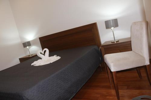 诺德什蒂CASA DO ADRO -GRANEL的一间卧室配有一张床和一把椅子