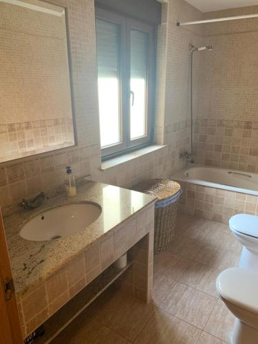 La HorcajadaCasa Rural Los Tasajos的浴室配有盥洗盆、卫生间和浴缸。