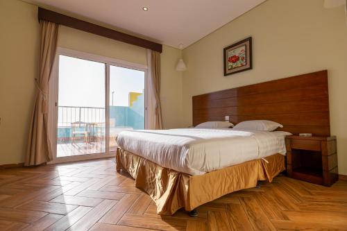 雷伊斯Al Jar Resort - Families Only的一间卧室设有一张大床和一个大窗户