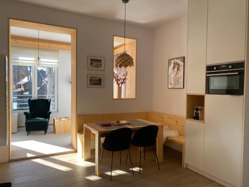扎科帕内Apartament Skiturowy Jagiellonska Residence的厨房以及带桌椅的起居室。