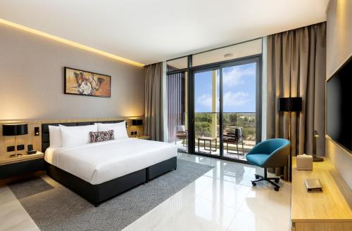 迪拜Millennium Place Mirdif的酒店客房设有一张床和一个大窗户