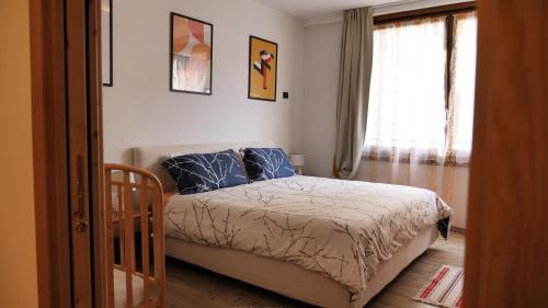 博尔米奥Al vecchio arcolaio的一间卧室配有一张带蓝色枕头的床和一扇窗户。
