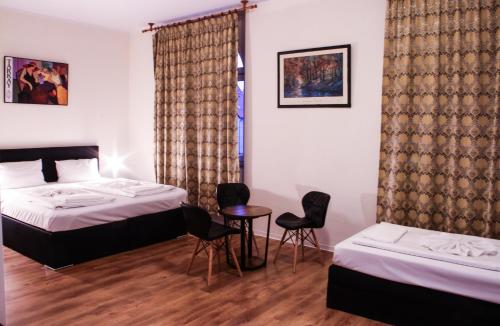 柏林卡尔舒斯特酒店的一间卧室配有两张床和一张桌子及椅子