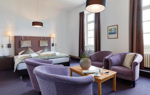 诺伊马根-德赫龙Hotel Lekker的酒店客房,配有床和椅子