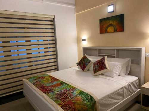 阿努拉德普勒Hummingbird Leisure Villa-Anuradhapura的卧室配有一张带白色床单和枕头的大床。