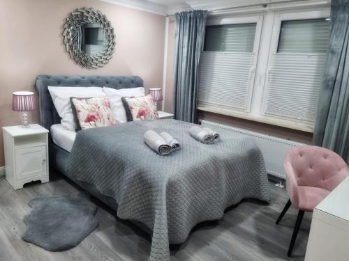 不莱梅R&S Apartments Bremen的一间卧室配有一张床和一张粉红色的椅子