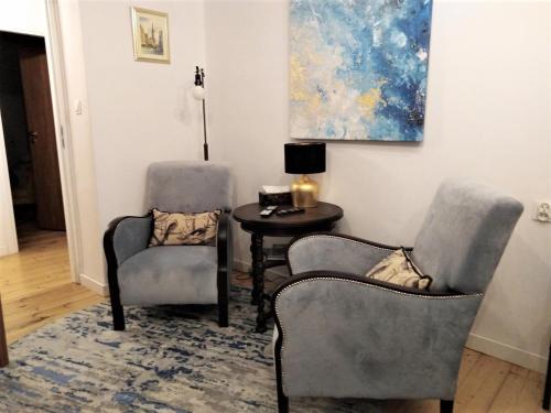 格但斯克Wygodny Apartament w Śródmieściu Gdańska的画室里配有两把椅子和一张桌子