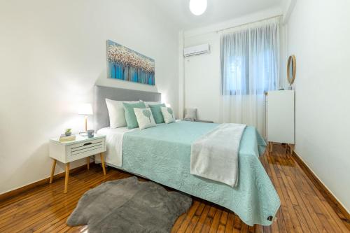 雅典Nadia’s Boutique Apartment, Athens的白色卧室配有一张床和床头柜,配有四柱床