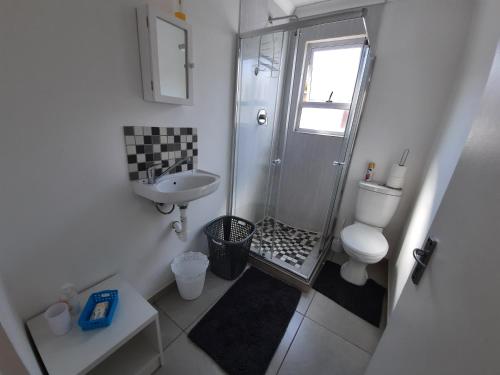 开普敦Covenant Place的带淋浴、卫生间和盥洗盆的浴室