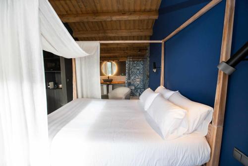 贝塞特Mochoruralhome ulldemo suite的卧室配有白色床和蓝色墙壁