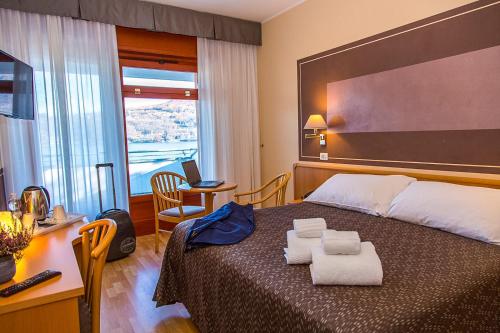 阿维利亚纳Hotel Chalet del Lago的酒店客房,配有带毛巾的床