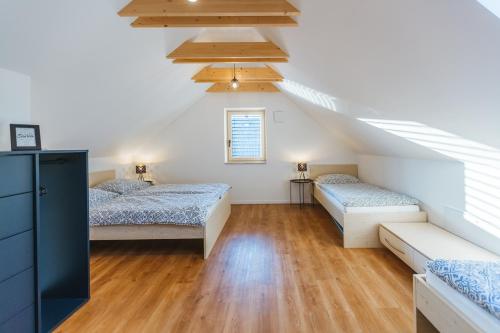 布莱德Maple & Pine Bled的阁楼卧室设有两张床和楼梯。