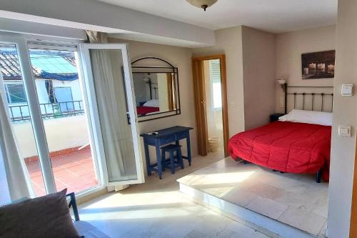 格拉纳达Hostal El Olivo的卧室配有红色的床和滑动玻璃门