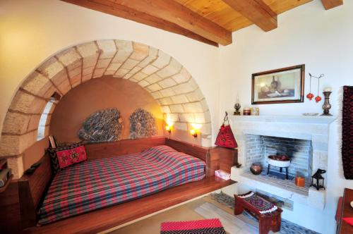 莫奈姆瓦夏Izambo Guest Houses的砖砌壁炉间内的一张床位