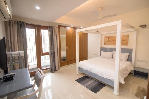 新德里Aashianaa Gracious Living的卧室配有白色的床和电视。