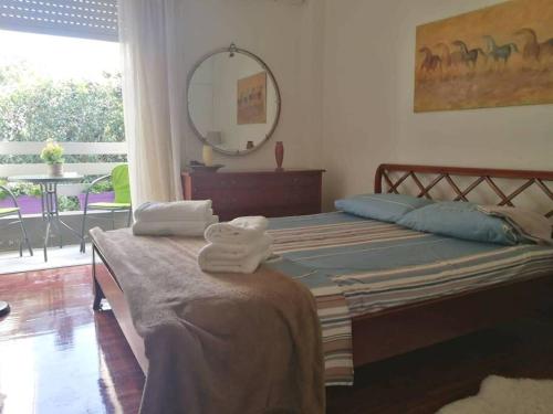 雅典Maria's Cozy apartment in Palaio Faliro的一间卧室配有带毛巾的床
