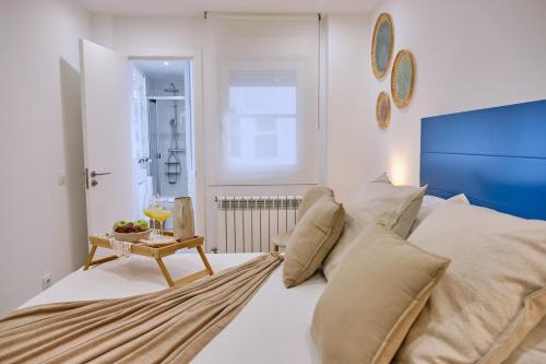 圣地亚哥－德孔波斯特拉Apartamento San Pedro的一间卧室配有一张带枕头和桌子的床