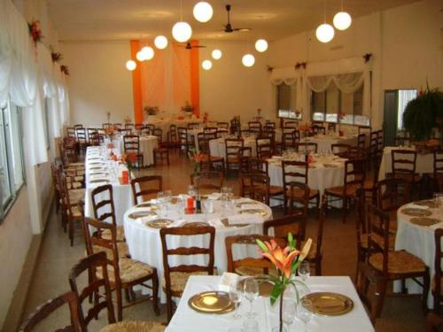 比亚莱特马西Complejo Turistico - Hotel Pinar serrano - Bialet Masse - Cordoba的一间设有白色桌椅的用餐室