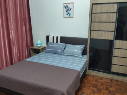 峇都丁宜Pinang Beach Cottage @ Ferringhi的一间卧室配有一张带蓝色枕头的床