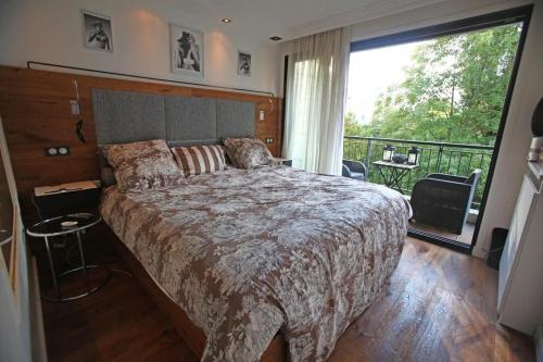 塞纳河畔讷伊George Apartment in Neuilly的一间带大床的卧室和一个阳台