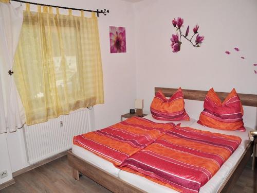 雷特温克尔Haus am Wiesengrund的一间卧室配有一张带红色枕头的床