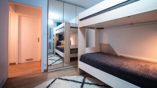 科尔马Superbe appartement au coeur du Colmar的一间卧室配有双层床和镜子