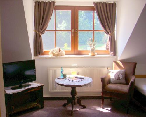 PostersteinElegant-Hotel "Zur Burg"的客厅配有桌子和窗户