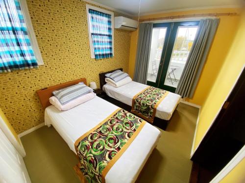 今津Shanshui House 箱館山的带三张床和窗户的客房