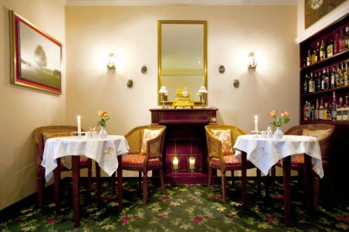 曼海姆科法尔斯图本酒店的一间带2张桌子和钢琴的用餐室