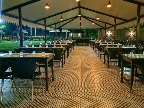 班加罗尔Vistar Resort & Hotels的用餐室配有桌椅和灯光