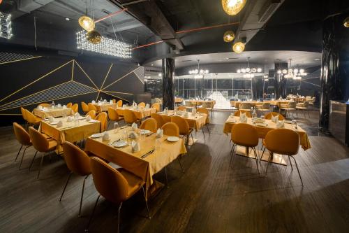 科泽科德Fezinn Hotel - Best Wayanad Hotel in 2024的餐厅设有木桌和黄色椅子