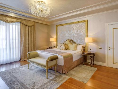 阿斯塔纳里克瑟斯酒店的一间卧室配有一张大床和一个吊灯。