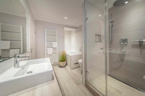 瑞汀Beach 4的白色的浴室设有水槽和淋浴。
