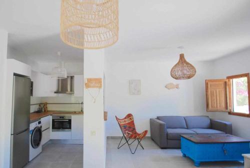 厄尔·坎皮洛·德·罗达尔La Sirena Azul de Rodalquilar的一间带蓝色沙发的客厅和一间厨房