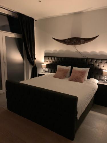 安特卫普Appartement op Italiëlei的卧室配有一张带白色床单和枕头的大床。