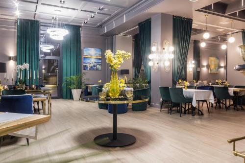 基希讷乌城市公园酒店的一间设有绿色窗帘和桌椅的餐厅