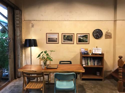 素叻Boundary Hostel and Cafe的餐桌、椅子和墙上的时钟