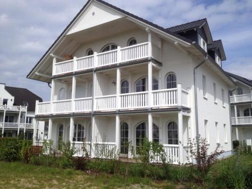 奥斯特巴特宁哈根Ferienwohnung Meeresrauschen的大型白色房屋设有大阳台
