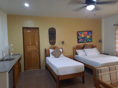 爱妮岛Eastwind Beach Club- El Nido的酒店客房设有两张床和盥洗盆