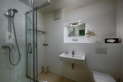 柯尼希斯武斯特豪森索菲霍夫酒店的白色的浴室设有水槽和淋浴。