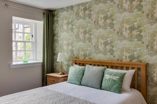 弗福尔Balgavies Home Farm - Cottage的一间卧室配有一张带花卉壁纸的床